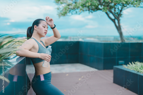 Bild auf Leinwand Young woman feeling tired and exhausted after a hard workout session, pausing to