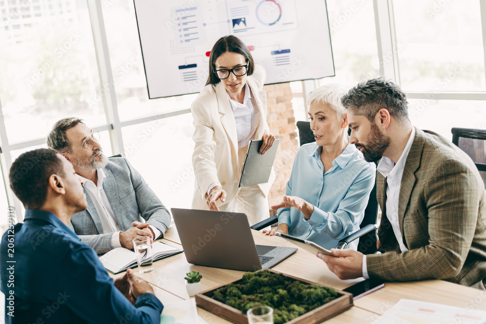 Naklejka premium Professional team discussing business strategies in a modern office environment with a focus on collaboration and innovation