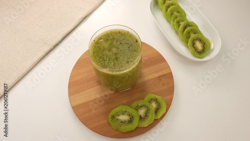 Fresh green kiwi smoothie on white table.