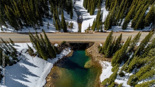Aerial view of a mountain road bridge over a turquoise river landscape