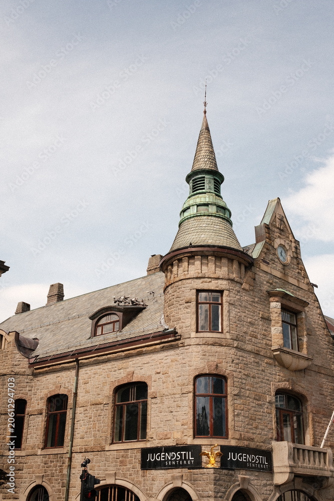 Obraz premium Historic stone building with a tall spire against a blue sky background