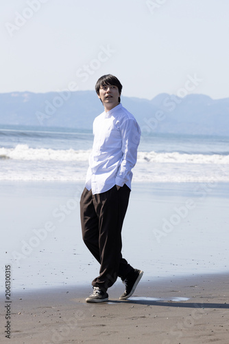 波打ち際を歩く男性