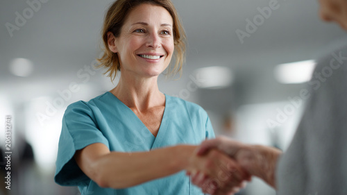 Nurse patient care hand hospital smile female medical support with warm greeting in clinic during compassionate visit
