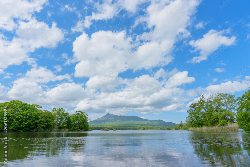 Fototapeta premium Mount Hokkaido Komagatake and Onuma Park in southern Hokkaido, Japan. Scenic view of Mount Hokkaido Komagatake rising beyond the islands of Onuma Park in southern Hokkaido, Japan. A famo