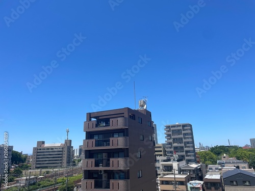 Naklejka 集合住宅と遠くの都会と青空
