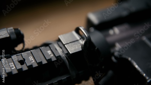 Photography This black tactical rifle features a modular rail system with an attached hologr
