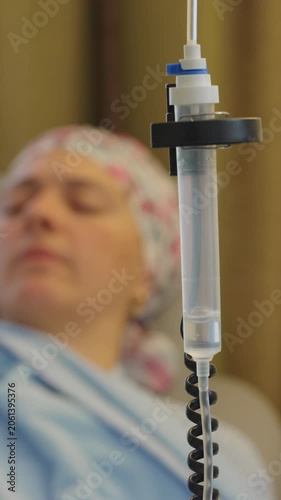 Chemotherapy infusion chamber with visible medication drops falling through intravenous line highlighting precision oncology treatment controlled drug delivery