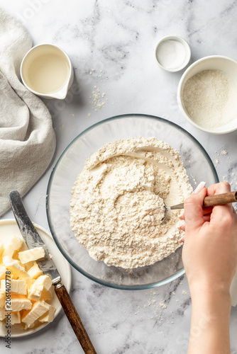 Process of making a base for shortbread pie, tart or quiche. Female hands mixing the dough ingredients. Home baking culinary concept, recipe. Flat lay