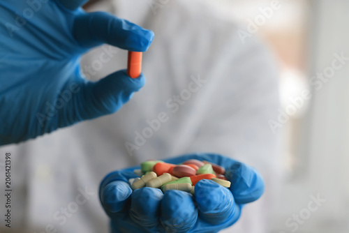bunch of different pills in the hands of a doctor in blue gloves close-up background pharmacy