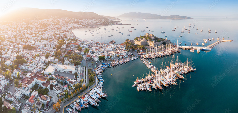 Obraz premium Bodrum city showing Castle of St. Peter and marina filled with many yachts on Aegean Sea during golden hour