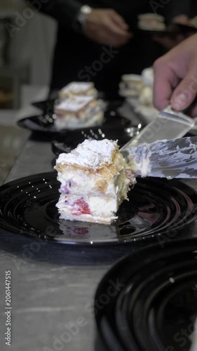 Vertical: A chef carefully arranges slices of celebration cake on individual plates, preparing the final sweet course for guests enjoying a memorable catered restaurant party event.