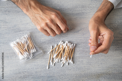 Caucasian man showing cotton bud for ear cleaning.