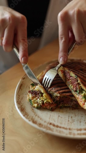 Close Up Shot of Person Cutting Grilled Crispy Panini Sandwich with Knife and Fork