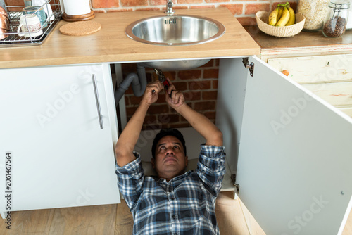 Photography Man fixing kitchen sink plumbing