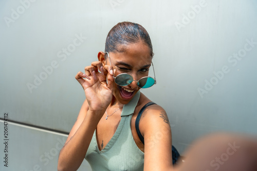 фотографія Young woman winking while taking playful selfie