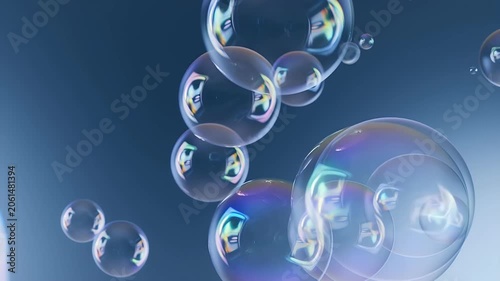 Numerous iridescent soap bubbles float and drift through a soft blue gradient background in this abstract stock photo.