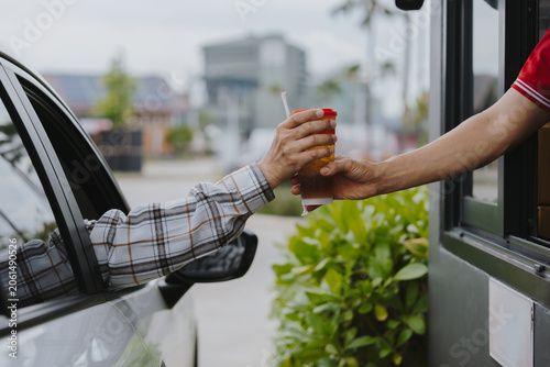 People pick up food and drink glasses from drive-thru counters and take them to eat at home and at work.	