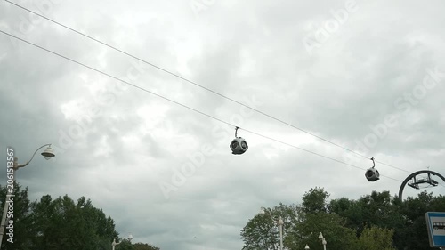 Cable car cabins fly over the city. Filmed in motion