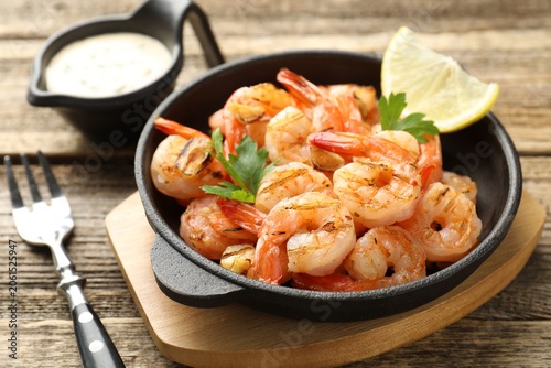 Bild auf Leinwand Tasty grilled shrimps served with sauce on wooden table, closeup