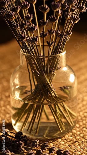 Burning incense sticks in glass holder with warm glow