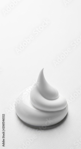 A smooth swirl of thick white cosmetic cream sits elegantly against a plain white background, showing a soft texture and a glossy finish, stroke, dab, spa
