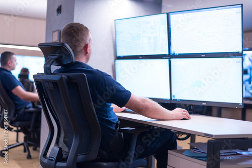 Security Guard Monitoring Multiple GIS Maps on Multi-Monitor Setup