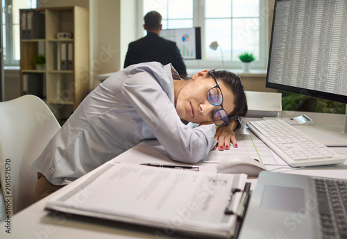 Schilderij op canvas Tired woman employee sleeping at office desk