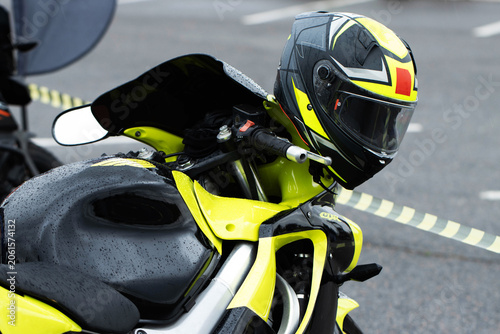 Bild auf Leinwand Motorcycle with vibrant neon yellow and black racing helmet parked outdoors on w