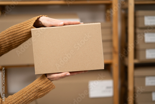 Close-up of SME small business entrepreneur holding box packaging. Concept of online sales.