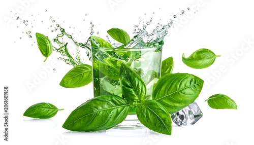 A refreshing glass of water with basil leaves splashing into it