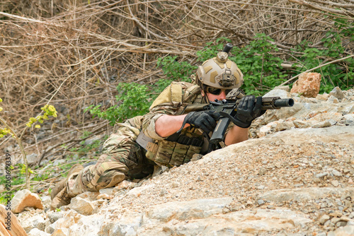 Foto The sacrificing soldiers lie prostrate on the ground camouflaged behind rocks preparing fire upon the enemy on the ground in a ready to attack stance