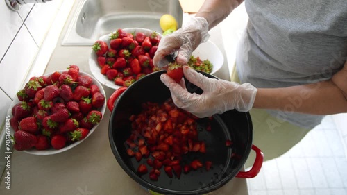 Slow motion of woman's hands cutting strawberries