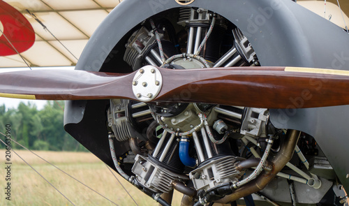 Vintage aircraft engine detail with wooden propeller in open field