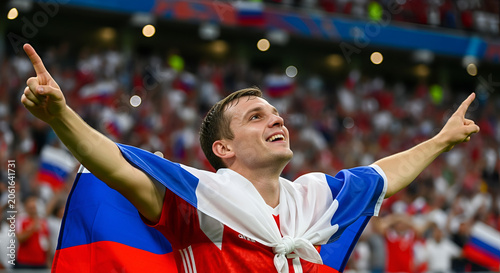 Russian Football Player Celebrates Victory, Flag draped around shoulders, stadium crowd