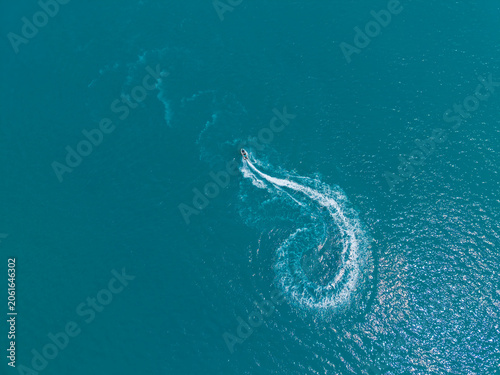 Photography Watercraft moves quickly in a circular path across the blue ocean during a sunny