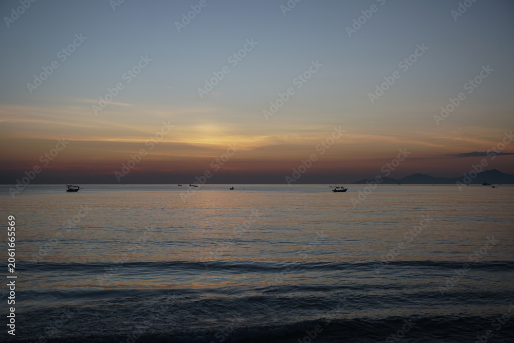 Fototapeta premium Fishing boats at sea with sunrise in the background. Dawning sky before sunrise