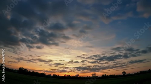 Sweeping time-lapse sunrise to daybreak over vast tranquil natural landscape. Ultra-wide establishing video, static camera, deep crisp focus, colossal sky transitions indigo to golden. Serene natural