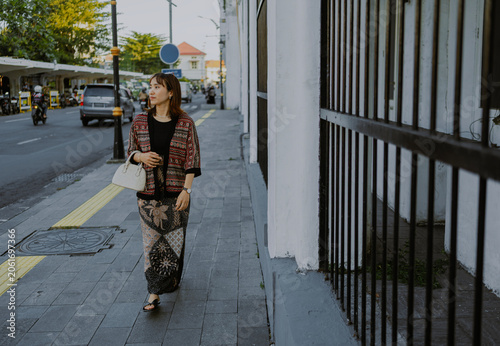 Stylish Asian woman in modern clothes batik walking on the city street, east java, Indonesia.