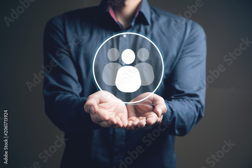businessman holding a social network icon on a dark background, man and people icon