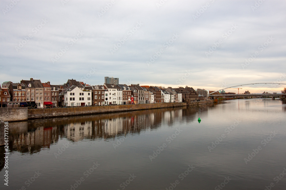 Fototapeta premium Scenic view of the historic Meuse river embankment with architectural reflections in Maastricht