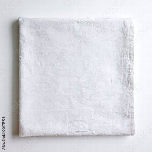 White fabric is folded and placed on a smooth surface, showing texture and color in natural light during the day