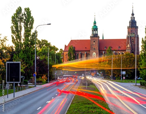 A serene cityscape with a historic brick church and vibrant traffic lights