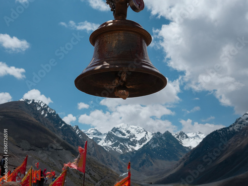 Tableau sur toile Temple bell overlooking snow-covered Himalayan mountains in Uttarakhand, India, at a sacred pilgrimage destination