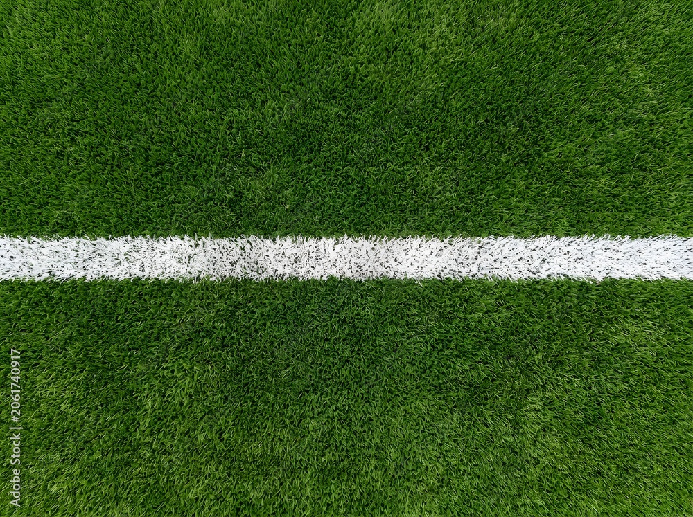 Fototapeta premium Close-up of clean white line markings on a green soccer field