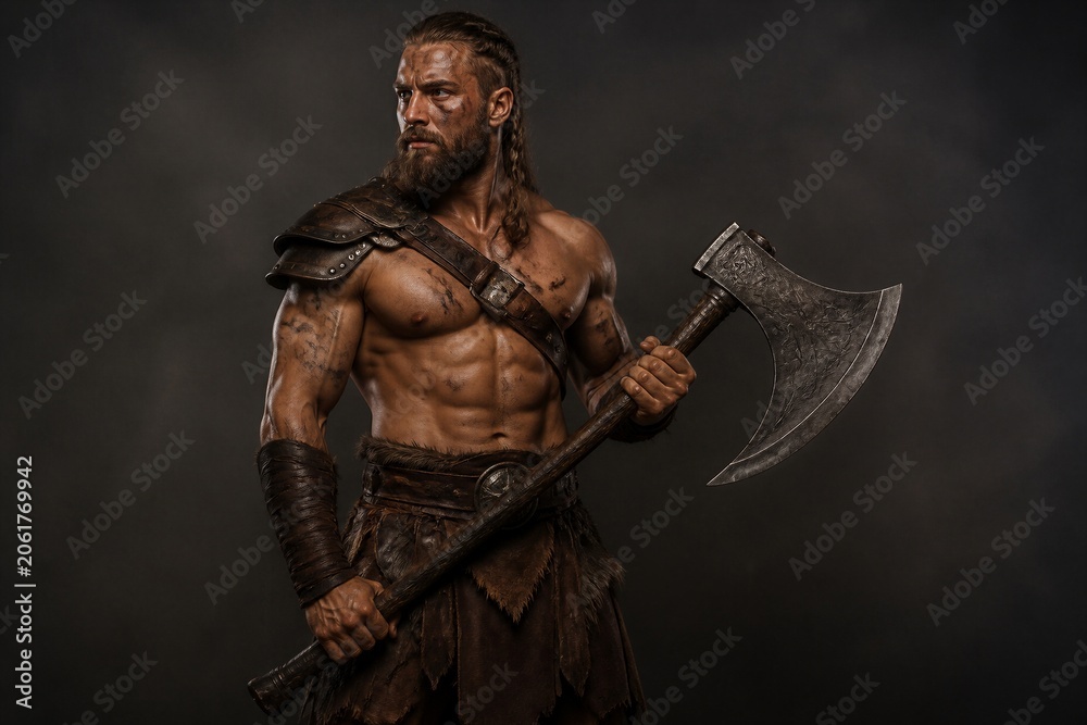 Obraz premium Barbarian warrior holding battle axe in studio setting