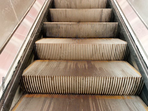 Close-up of escalator steps with brown seats