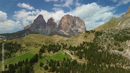 Aerial mountain valley with winding road and dramatic alpine peaks