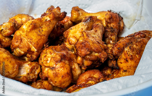 Woodfire grilled chicken wings in a napkin lined bowl