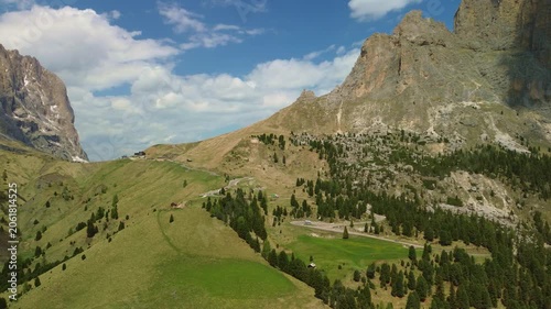 Alpine mountain valley with green hills and rocky peaks