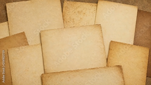 A collection of vintage paper sheets with worn edges and aged texture on a brown background